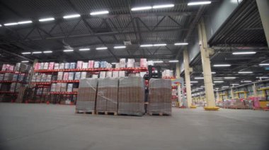 Deponun içinde bir sürü karton kutu var. Yaratıcı. Yükleyici makine çalışıyor