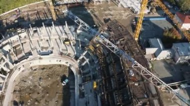 Stadyum tribünlerinin ve büyük inşaat alanındaki makinelerin beton temeli. Stok görüntüleri. İnşaat alanının arkasındaki Summer City caddeleri