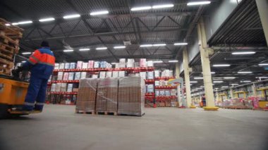 Profesyonel Depo çalışanları güvenlik üniforması giyip forklift kullanıyorlar. Yaratıcı. Depolama tesisi.