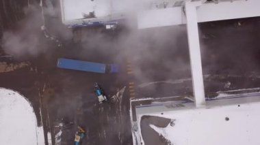 Yarı karavan kamyonları olan modern bir lojistik merkezinin havadan görünüşü. Yaratıcı. Şehrin sanayi bölgesinde bir depo çatısı.