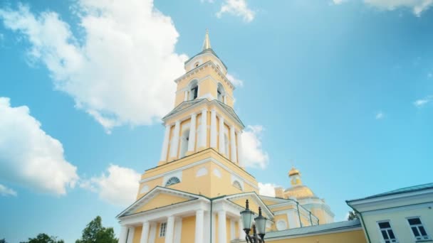 青い曇りの夏の空の背景にある黄色い大聖堂の建物の低い角度の景色 クリップ アーキテクチャーテーマ — ストック動画