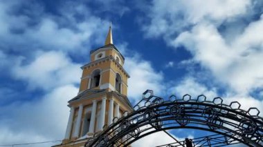 Zaman hızlandırılmış bulutların mavi gökyüzünde Hristiyan Kilisesi üzerinde hareketi hızlandı. Şarjör. Din kavramı, kilise kulesinin düşük açılı görüntüsü.