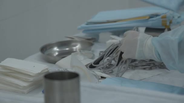 手術の準備のためにテーブルの上に医療用具のテーブルが置かれています ストック映像 テーブルの上に楽器を置く看護師 — ストック動画
