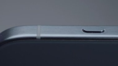 ABD, New York - 15 Eylül 2023: Yeni iPhone dosyasının yakın plan tasarımı. Başla. Tecrit edilmiş arka planda yeni iPhone 15 'in şık tasarımı. Yeni iPhone 15 profesyonelinin yanında düğme. 