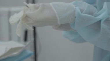 Lateks eldivenli eller. Başla. Doktor ellerine plastik beyaz steril eldiven takıyor. 
