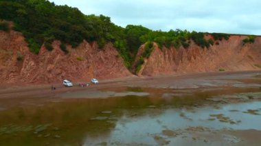 Turistlerle ve kayalık geçitlerle kıyı manzarası. Şarjör. Kayalarla ve turistlerle dolu harika bir sahil. Kayalık uçurumun kıyısında turistlerle dolu bir orman vadisi.. 