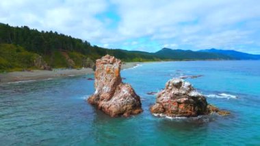 Turistlerle dolu deniz ve sahil manzaralı kayalar. Şarjör. Kayalıkları ve turkuaz suyu olan güzel bir sahil. Deniz kıyısında kayalıklarla kamp yapmak..