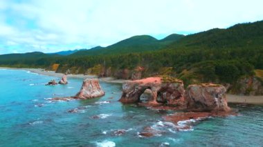 Deniz kıyısındaki muhteşem uçurumların en üst görüntüsü. Şarjör. Deniz dalgalarının aşınmasıyla oluşan kayalar inanılmaz taş kemerler oluşturur. Deniz kıyısındaki güzel kayalık kemerler. 
