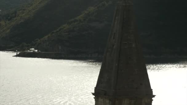 美しい川と緑の山の後ろにある古代の塔 クリエイティブ アーキテクチャの概念 — ストック動画