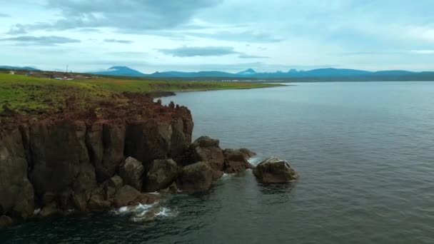 オレゴン海岸の落ち着いた海と石の崖のバードアイビュー クリップ 海洋水面と緑の牧草地の航空機 — ストック動画