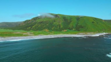 İskoçya 'nın Skye Adası' ndaki denizin kıyısındaki yeşil çayır ve dağların havadan görünüşü. Şarjör. Yaz doğası kavramı