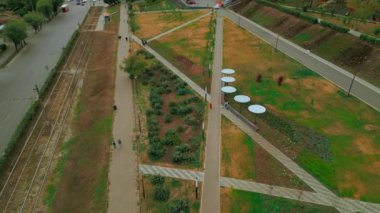 Şehirdeki park alanında yürüyen insanların en iyi görüntüsü. Şarjör. İnsanlar modern şehir parkında yürüyüp rahatlıyorlar. Güneş panelleri ile şehir parkının manzarası. 