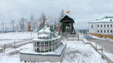 Kış günü altın kubbeli Hristiyan kilisesinin havadan görünüşü. Şarjör. Köy yerleşimi, karlı kırsal bölge dini tapınak ve binalar