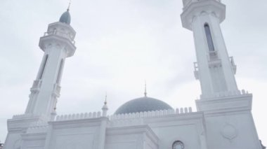 Beyaz ve gri tarihi bir cami. Sahne. Bulutlu arka planda minareleri olan dini bir bina