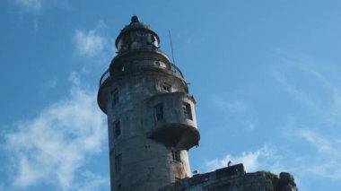 Denizde terkedilmiş muhteşem deniz feneri manzarası. Şarjör. Güzel deniz feneri denizde terk edilmiş. Güneşli bahar gününde görkemli terk edilmiş deniz fenerinin yanından geçiyor..