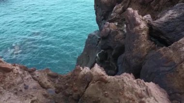 Su kenarındaki güzel kayalar. Şarjör. Sahil kayalıkları ve sakin deniz suyu. Taştan kıyıdan deniz suyuna bak.. 