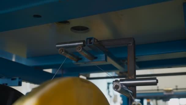 工場でワイヤーが付いている回転コイル クリエイティブ 金属工業のコイルのワイヤーの配分そして巻上げ 放出プロセスの間にコイルのポリマー ラインの巻上げ — ストック動画