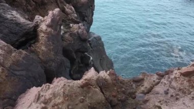 Su kenarındaki güzel kayalar. Şarjör. Sahil kayalıkları ve sakin deniz suyu. Taştan kıyıdan deniz suyuna bak.. 