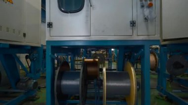 Endüstriyel girişimde dönen bobinler. Yaratıcı. Plastik alaşım ve polimer çubuk sarma işlemi. Endüstriyel fabrikanın kimyasal atölyesi.