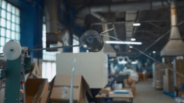 Metal şerit endüstriyel makinede dönüyor. Yaratıcı. Dönen bobinleri ve hareket eden alüminyum çizgileri olan endüstriyel bir makine. Metalürjik üretimde otomatik makineler. 