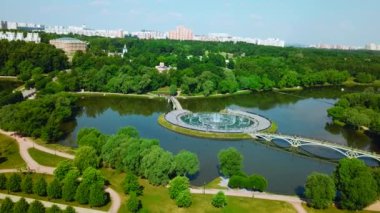 Şehrin göletindeki çeşmeli köprülerin en üst manzarası. Yaratıcı. Köprüleri ve çeşmeleri olan bir ada. Nehir adasında yaya köprüleri olan güzel bir çeşme kompleksi.