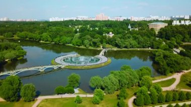 Şehrin göletindeki çeşmeli köprülerin en üst manzarası. Yaratıcı. Köprüleri ve çeşmeleri olan bir ada. Nehir adasında yaya köprüleri olan güzel bir çeşme kompleksi.