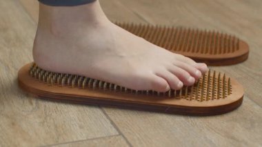 Çivilerin üzerinde duran kadının yakın görüntüsü. Medya. Çivilerin üzerinde durma alıştırması, duyguların gelişimi. 