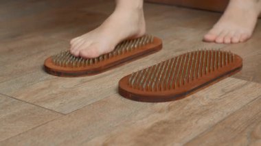 Çivilerin üzerinde duran kadının yakın görüntüsü. Medya. Çivilerin üzerinde durma alıştırması, duyguların gelişimi. 