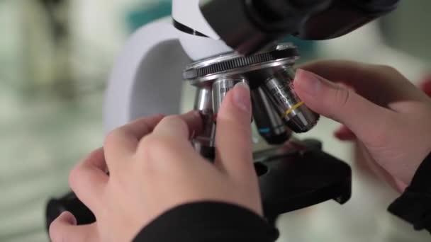 研究室で顕微鏡で検体の検査をクローズ アップ 血液研究室で顕微鏡をクローズ アップ 顕微鏡を用いた実験室および科学者の手でクローズ アップ — ストック動画