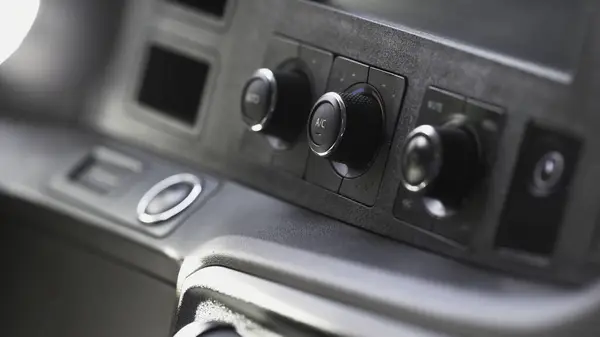 Modern car interior, details of dashboard. Close up of regulators of temperature or conditioner and volume on a dashboard of a new vehicle, transportation concept.