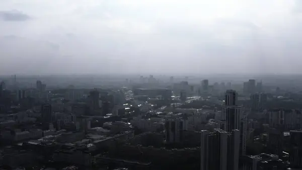 Top view of panorama of city in fog with sunlight. Stock footage. Beautiful view of panorama of city in fog on cloudy day. Urban landscape with horizon and fog.