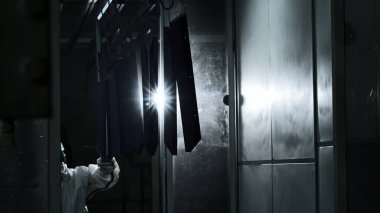 Koruyucu kıyafetli işçiler metal boruları çelik levhalarla itiyorlar. Yaratıcı. Endüstriyel çelik fabrikası.