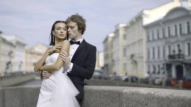 Avrupa caddesinde yeni evliler kucaklaşır. Başla. Yeni evliler, Avrupa 'daki binaların arka planında kucaklaşırlar. Yazın sokaklarda yeni evliler..