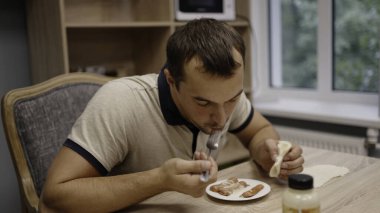 Nefis bir kahvaltı. Başla. Ev masasında güneşli bir sabahta krep yiyen bir adam. Yüksek kalite 4k görüntü