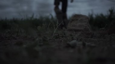 Erkek çiftçi kütük yuvarlıyor. Görüntü. Ayakkabının içindeki ayak, kütüğü yuvarlıyor.