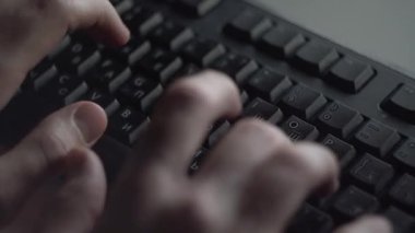 Klavyede yazarak adam close-up. Adam siyah bilgisayar klavye üzerinde iki elinizle yazarak.