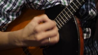 Kız balalayka oynuyor, yakın plan. Halk müziği enstrümanı Balalaika. Oyun 4K dizilerinde.