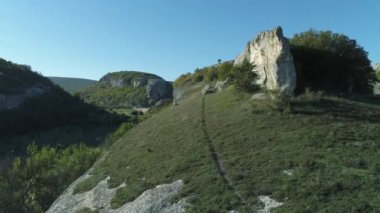 Mavi gökyüzünün altında bir vadi yeşil uçurumlarda güzel manzara. Muhteşem manzara