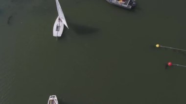Yelkenli yelkenli yarışı hava manzaralı lüks yatlar. Rüzgarda süzülerek göldeki dalgaların içinden geçiyor. 4K rüzgarlı bir günde açık denizde yelken açan Yat 'a inanılmaz bir manzara.