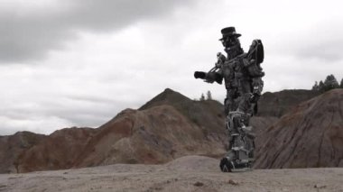 Çölde yürüyen bir robot. Görüntü. Android robot bulutlu bir havada dağ çölünde.