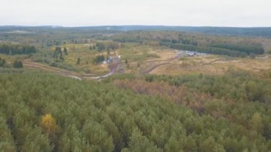 Arabalar ve kamyonlar ile orman ıslak ve kirli bir ülke yolunda. Havadan görünümü