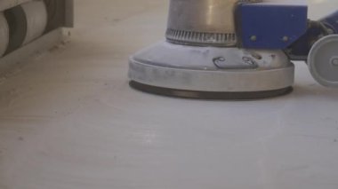 Yeni apartmanların inşaat sahasında havan döşemesi parlatan bir inşaat işçisi. Mekanize harç perdeli beton zemin yakın plan 4K