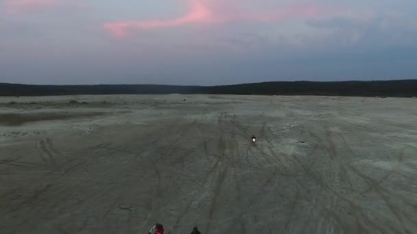 モトクロス レーサーは 砂のオートバイの大規模なプルームあたり砂欄干トラックに沿って移動します 砂の道を完了するバイクを熱望します 突然サンディのモーターサイク リスト演習に — ストック動画