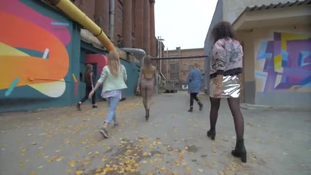 街の公園を歩いている陽気な女の子たち ヒップスターの女の子が通りを歩いている セクシーな女の子はクラブに行く リアビュー4K — ストック動画