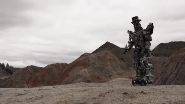 砂漠の風景の中を歩くロボット フッテージだ 曇った天気の山の砂漠のAndroidロボット — ストック動画