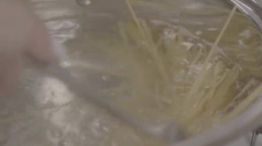Spaghetti 'yi yakın plan kaynatın. Sıcak suda spagetti pişirmek 4K