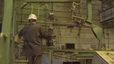 Metalurji fabrikasında boru üretimi yapmış. Büyük bir değirmenin yanında miğfer takan bir işçi. Metalurji fabrikasında çalışan işçi. 4K