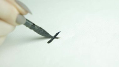 Geleneksel yazı fırçası. Çince yazı fırçası. Kız boş zamanlarında fırça kalemi kullanarak el yazısı çalışıyor. Kadın eli çizer. Kaligrafi 4K için geleneksel Çin fırçası kalem ve mürekkep