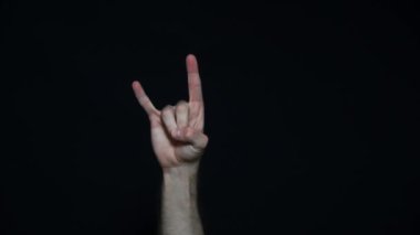 Siyah arka planda rock n roll işareti var. Şeytan boynuzu hareketi.