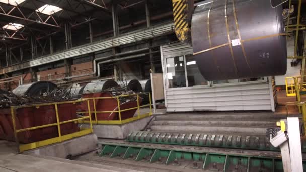 オーバーヘッドクレーン 自動倉庫保管施設内の指定された場所に鋼鉄コイルを運ぶコイル舌 頭上クレーンが付いている工場の鋼鉄屋根 倉庫内のスチールコイルハンドリング — ストック動画